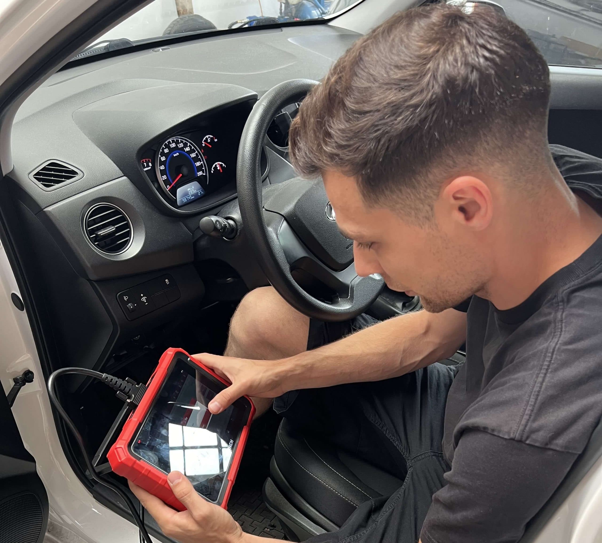 Technik prohlíží ojetý vůz před koupí